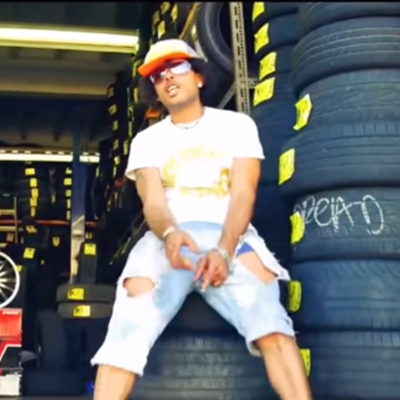 DJ facing a crowd at his deck. Photo with a purple hue